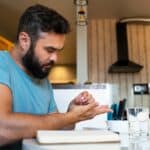diabetic man checking glucose patch sensor